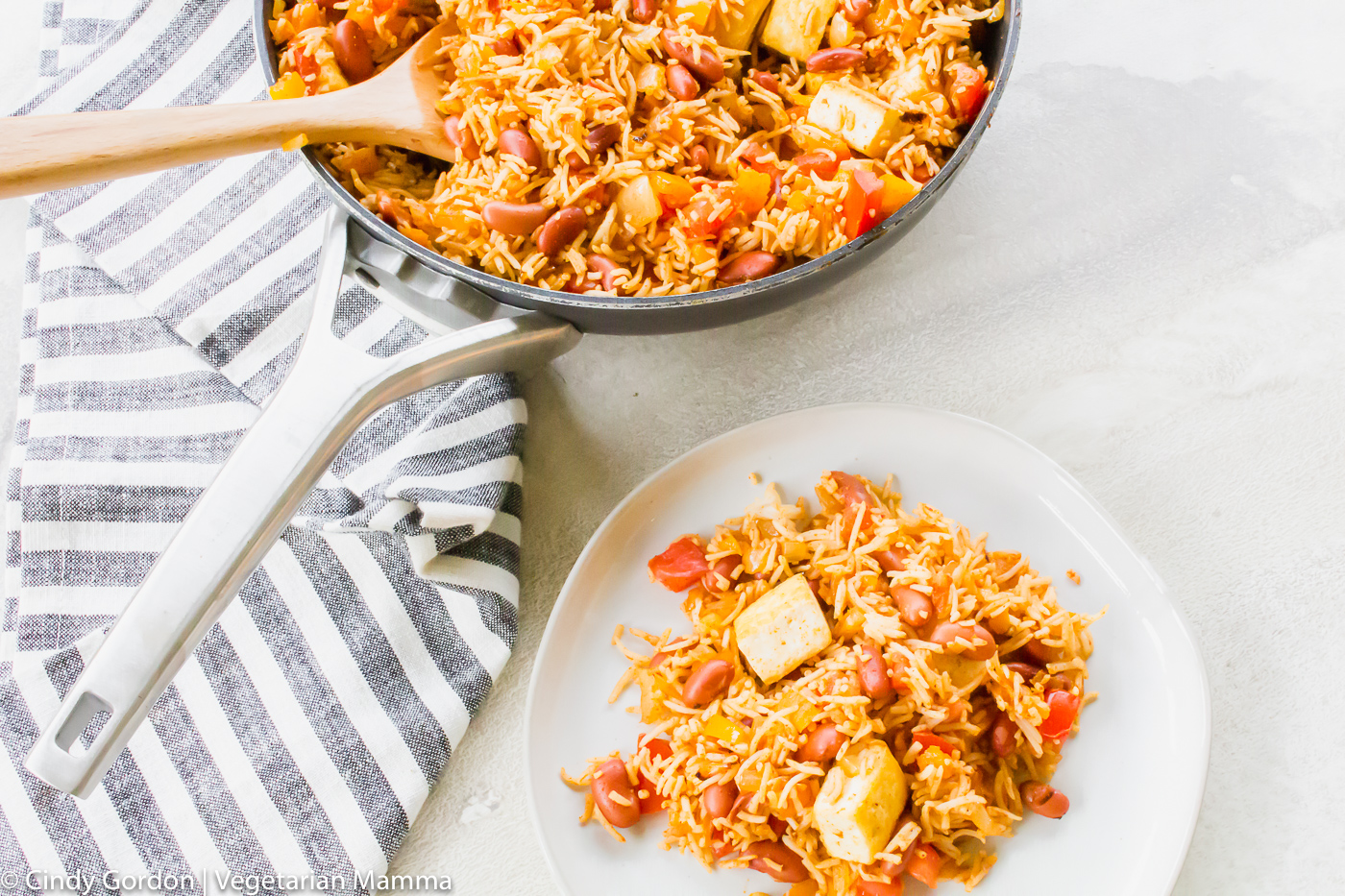 Tofu with spanish rice and bean shown in a skillet and on a white plate