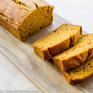 Pumpkin bread on wooden board atop white table