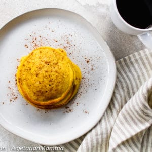 Top down view of Stack of gluten free pumpkin pancakes on round white plate