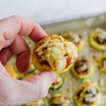 Hand holding up Zucchini Pizza with many more below