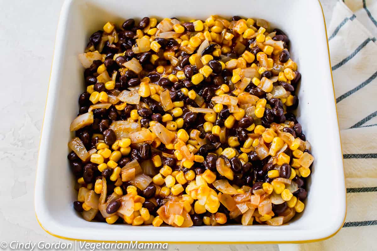 black bean, corn, and onion mixture on top of tater tots in casserole