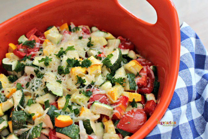 Baked zucchini topped with cheese in a casserole dish. 