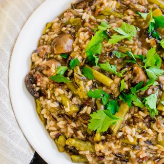 Mushroom and Asparagus Wild Rice in white bowl atop black counter