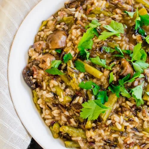 Mushroom and Asparagus Wild Rice in white bowl atop black counter