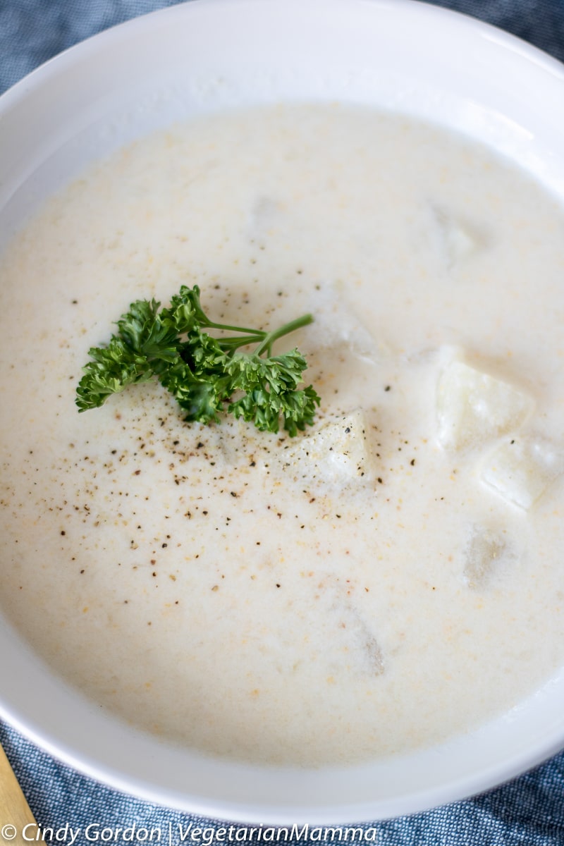 Overhead shot of rustic potato soup in a white bowl.