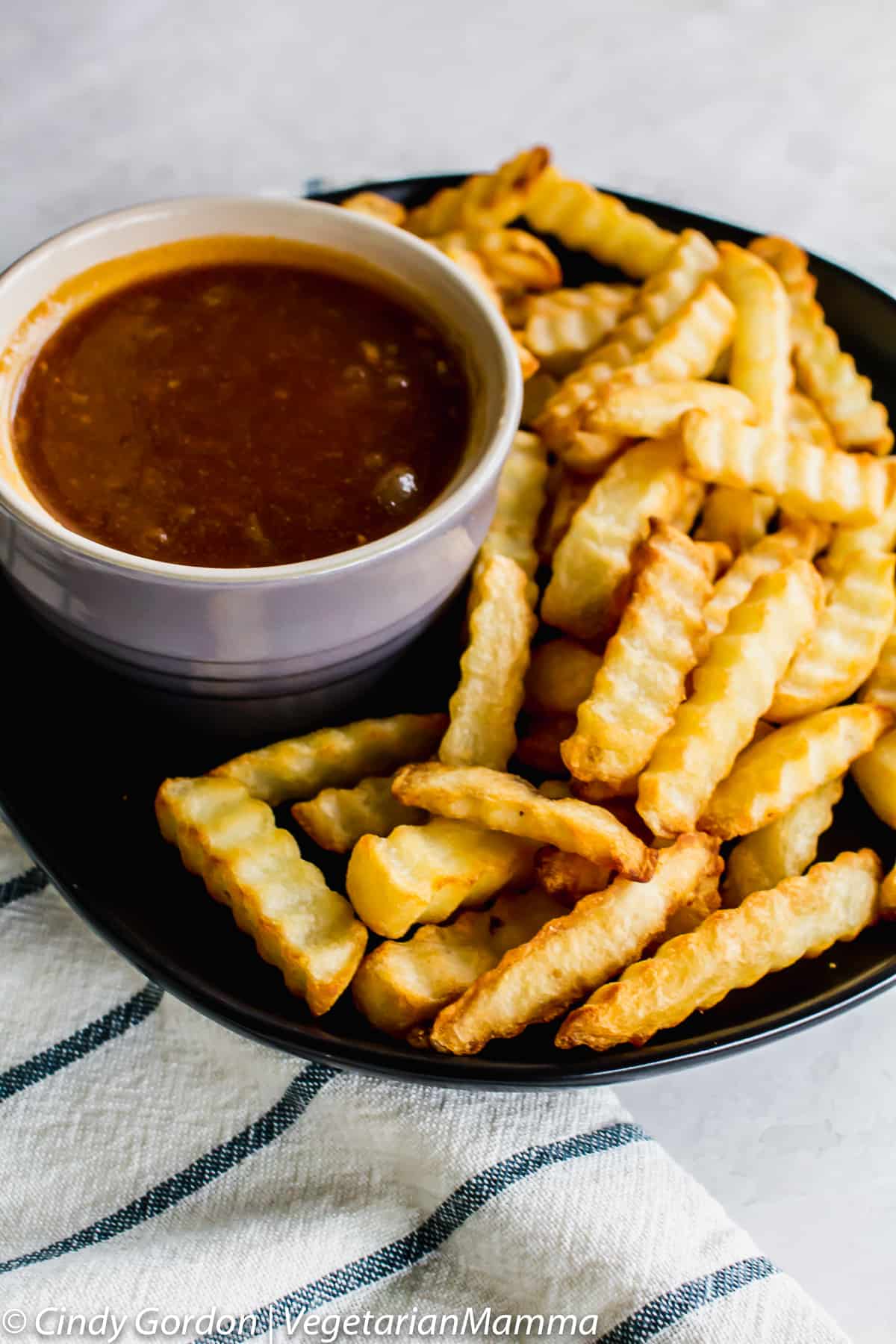 bowl of Dr Pepper BBQ Sauce on a plate with french fries