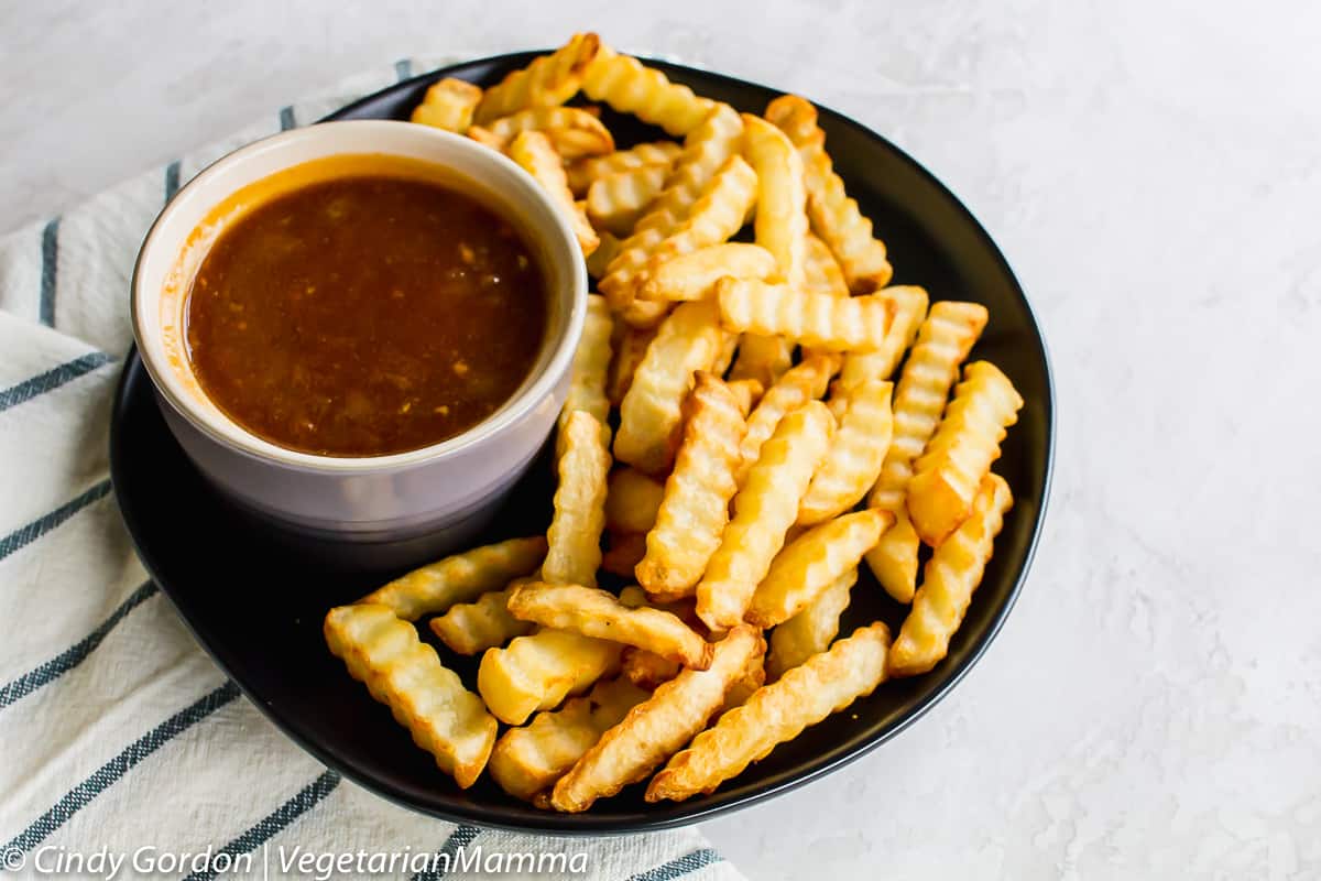 bowl of Dr Pepper barbecue Sauce on a plate with french fries