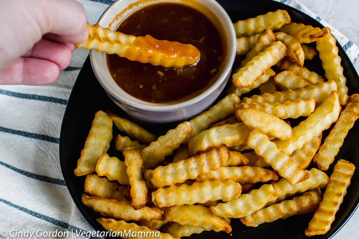 french fry dipped in Dr Pepper BBQ Sauce and a plate of french fries