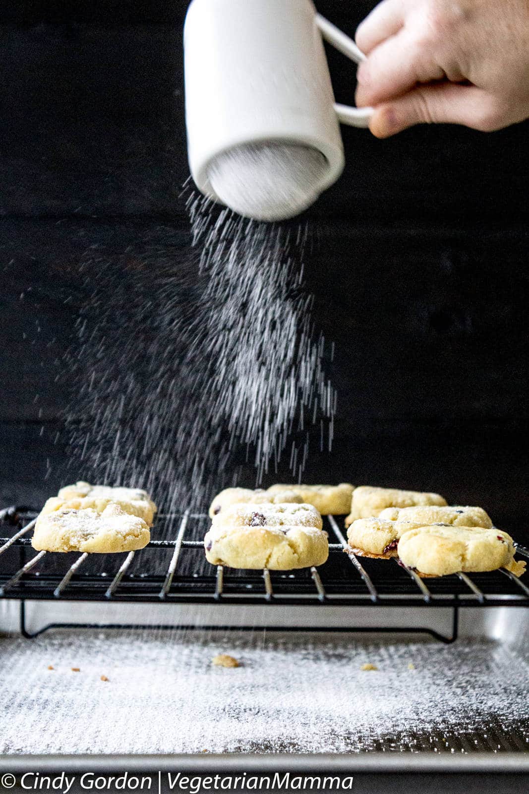 Sprinkling powdered sugar onto Gluten Free Lemon Cranberry Cookies