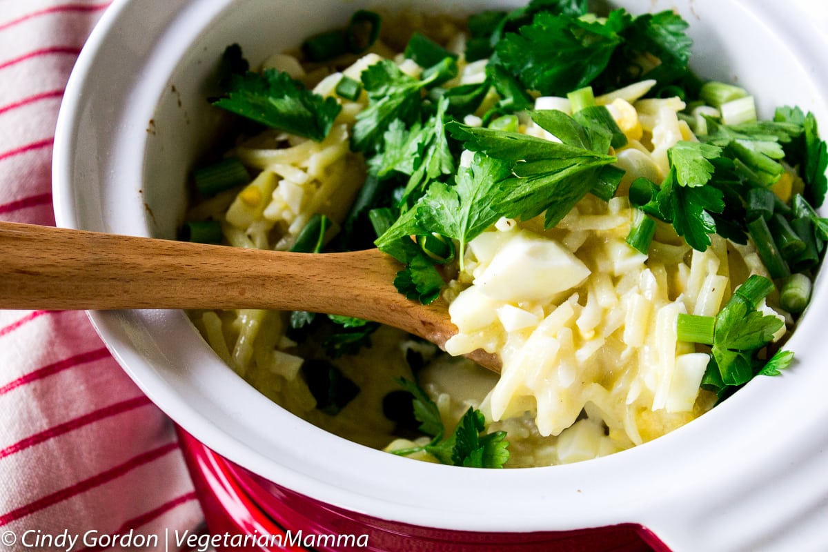 egg and hash brown casserole ingredients in bowl with wooden spoon