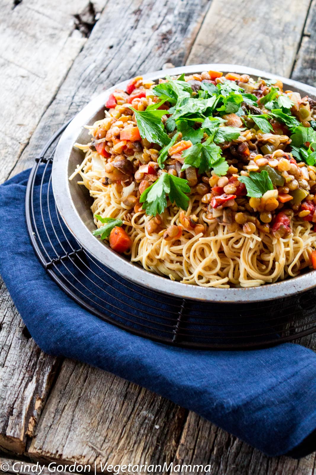 A bowl of vegetable ragu with lentils, carrots, and tomatoes, topped with fresh parsley