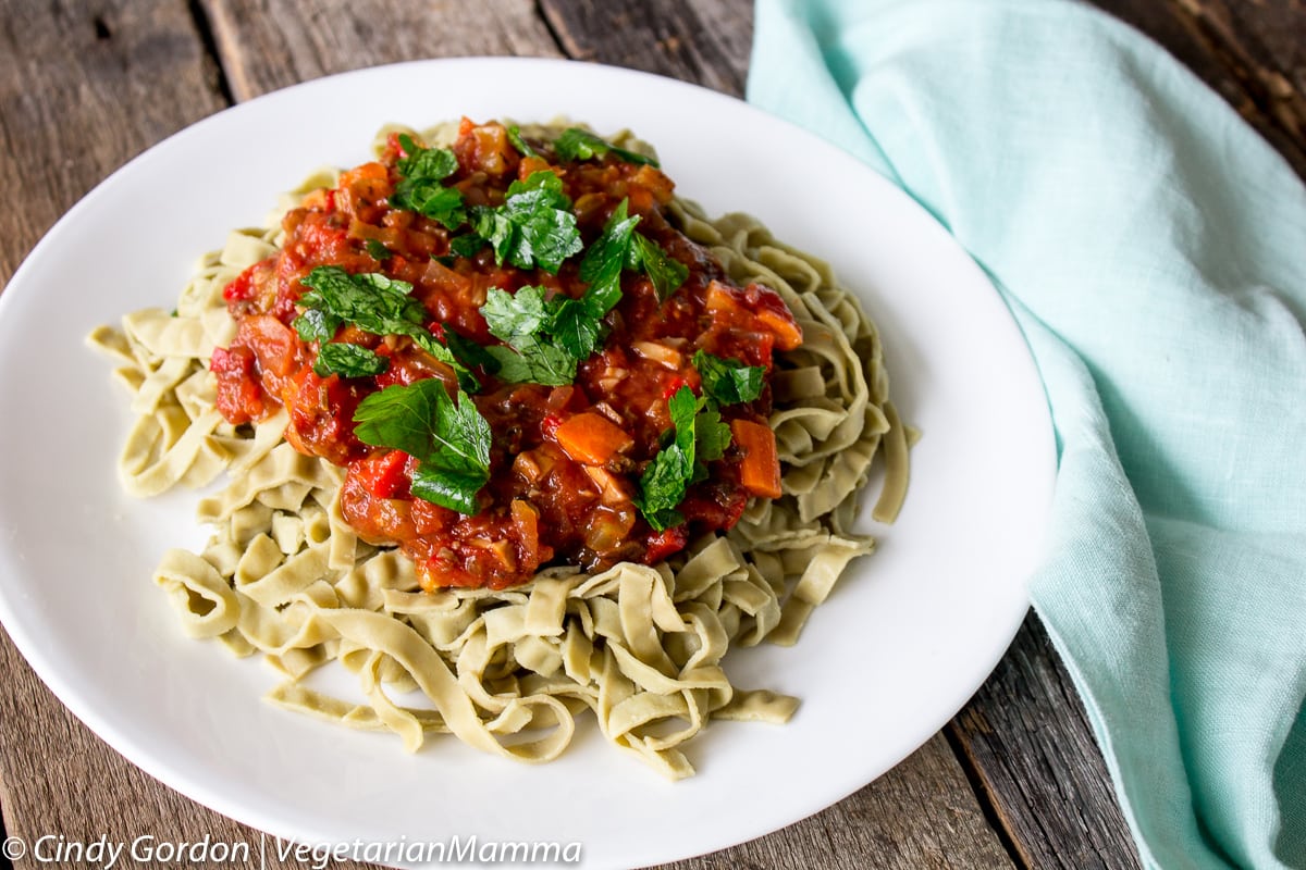 bowl of vegetarian bolognese over pasta topped with fresh parsley