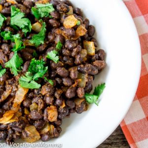 Easy Southwest Seasoned Black Beans inside of white bowl atop red and white cloth