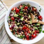 Mediterranean Chickpea Salad served in white bowl with striped cloth beside bowl
