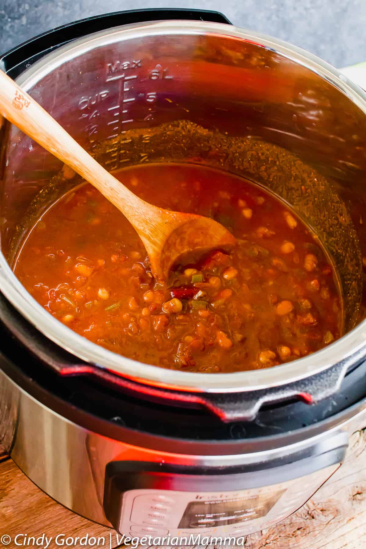 Instant Pot of Four Bean Chili with a wooden spoon in it 