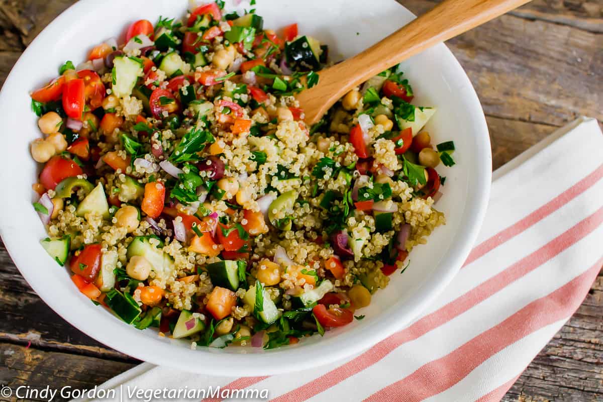 bowl of Mediterranean Quinoa Salad with a wooden spoon