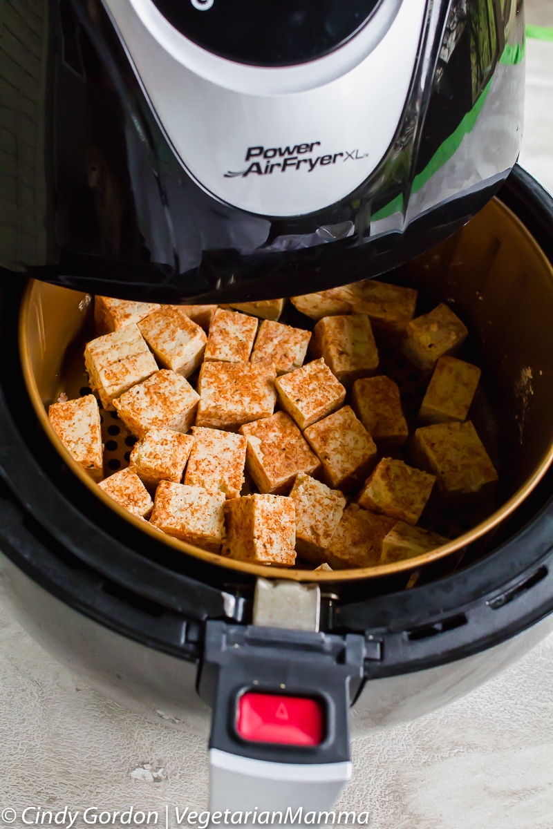 Tofu cubes being cooked in an air fryer