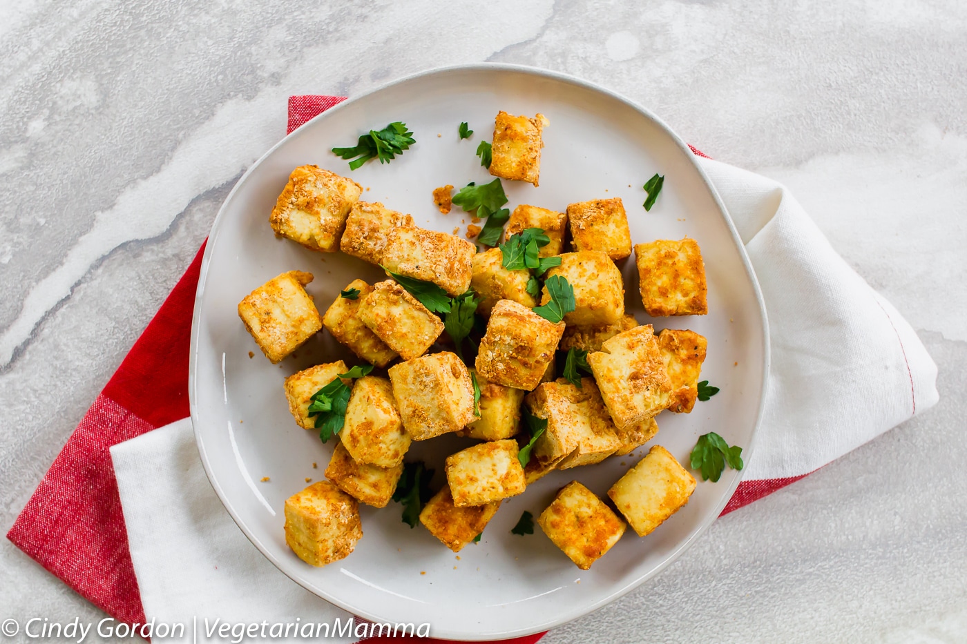 plate of air fryer tofu cubes with fresh parsley sprinkled over