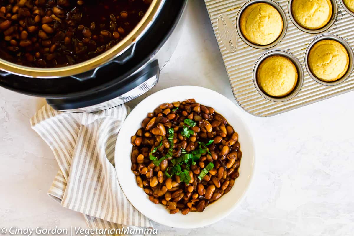 Overhead shot of vegan baked beans made in the instant pot with some corn bread muffins.