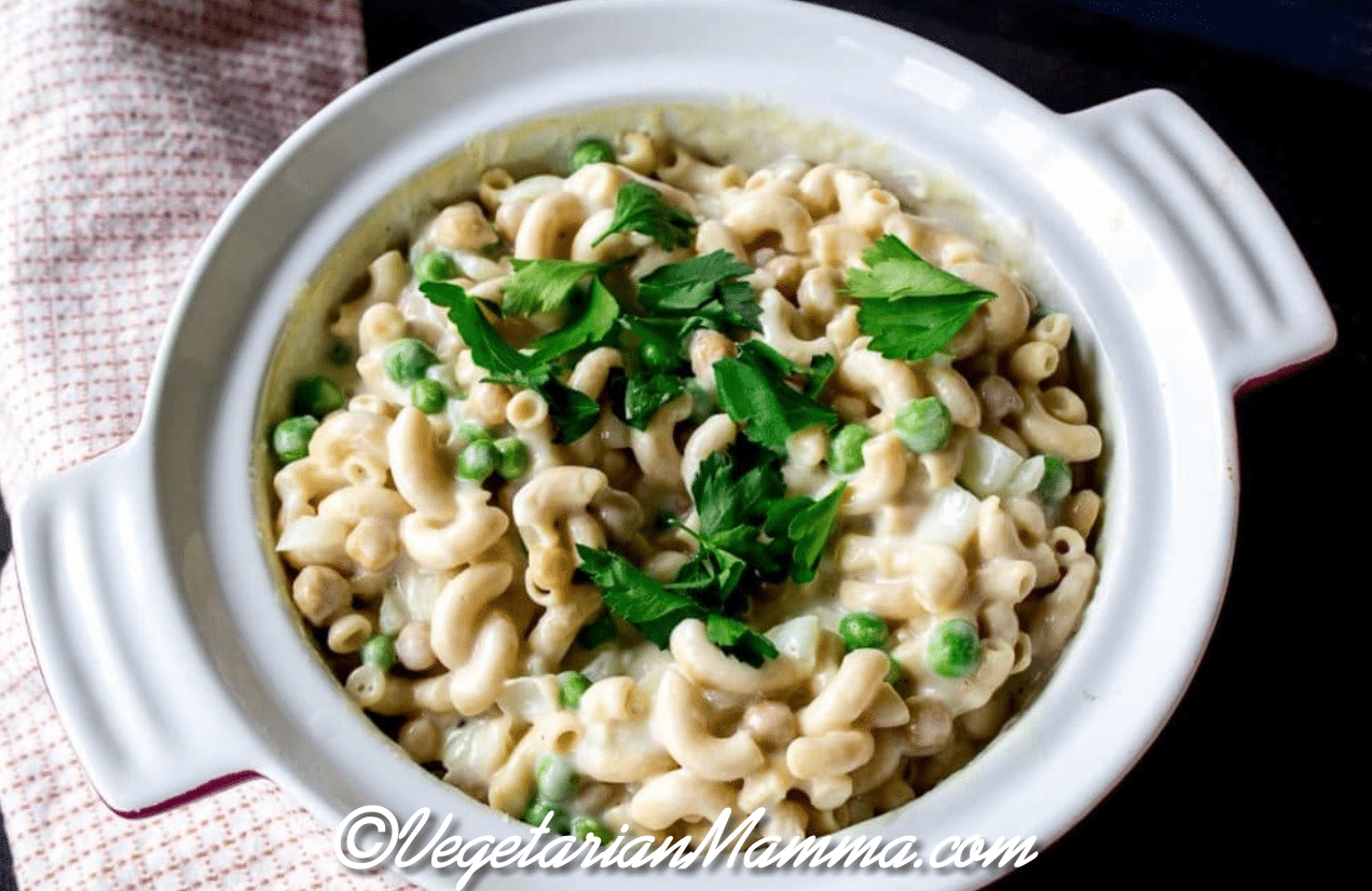 A white crock pot full of noodles and mock tuna with a sprinkle of parsley