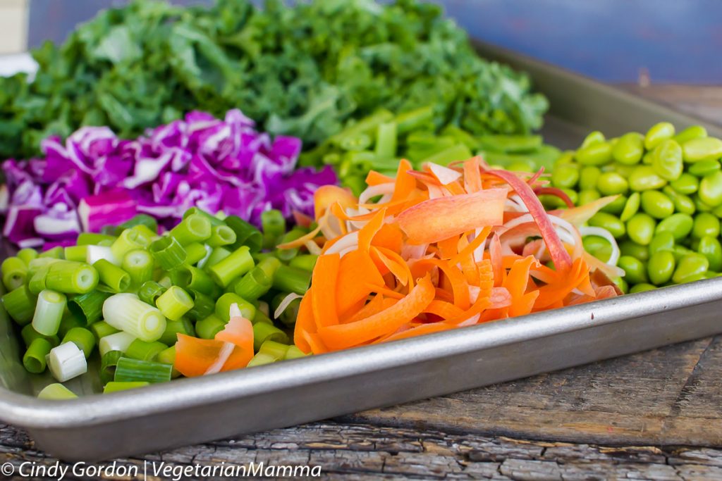 side view of ingredients for thai kale salad on a baking sheet