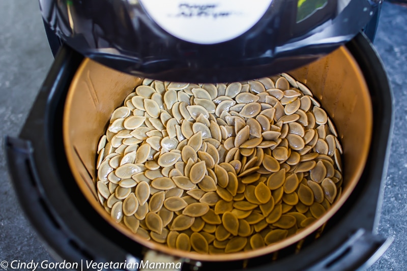 Air Fryer Pumpkin Seeds with seeds in air fryer basket.