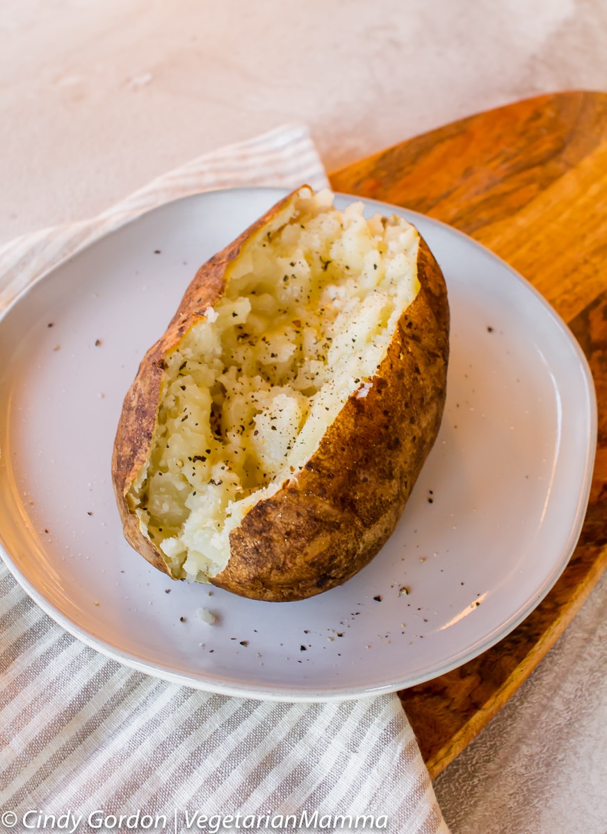 Air Fryer Baked Potato cut in half on a plate