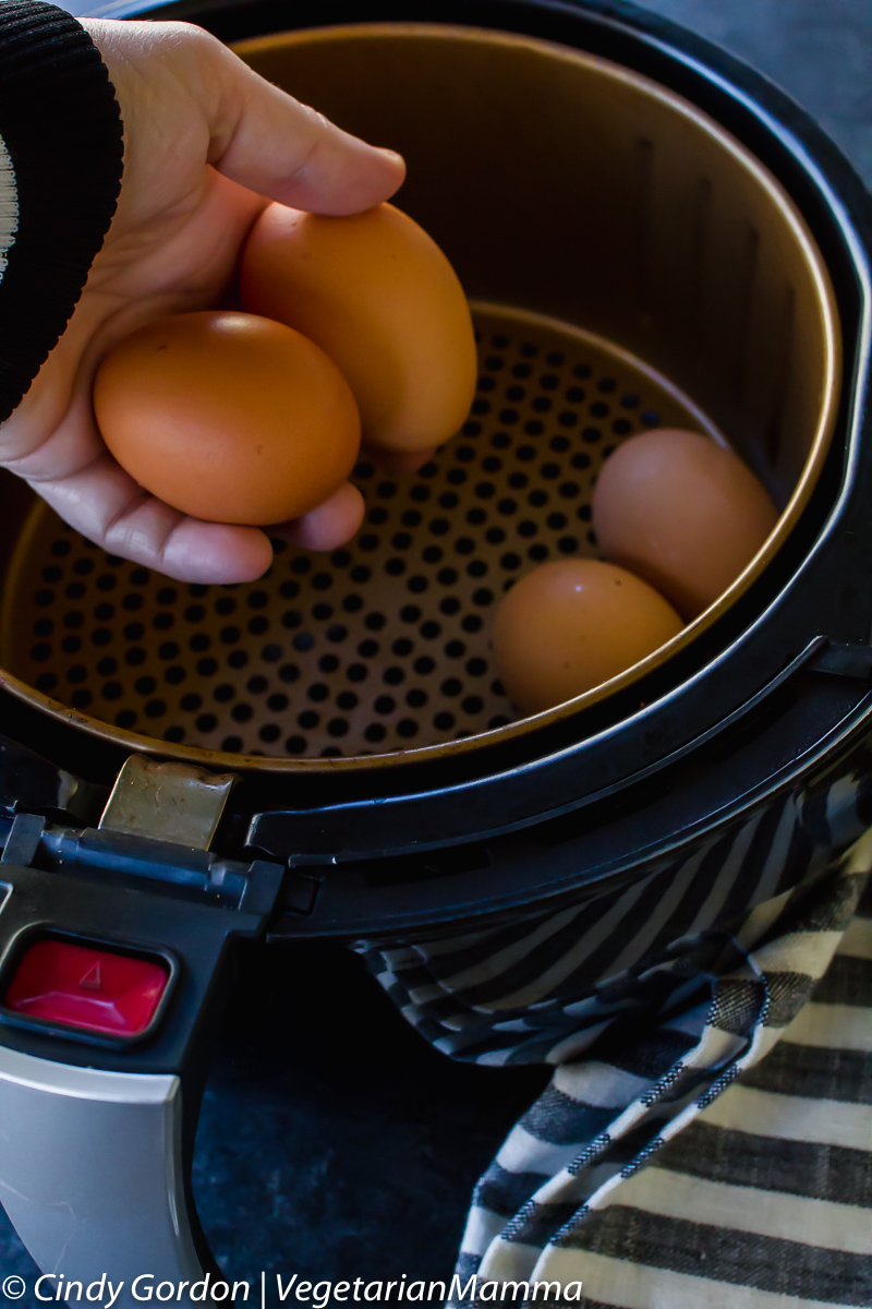 Eggs being placed into an air fryer basket