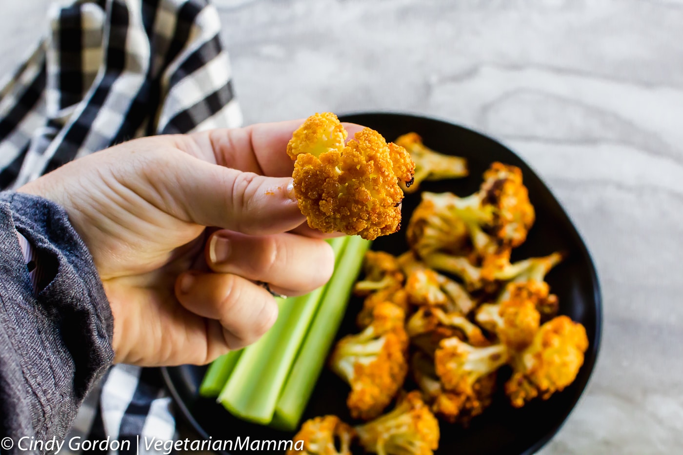 Air Fryer Honey Sriracha Cauliflower held in fingers