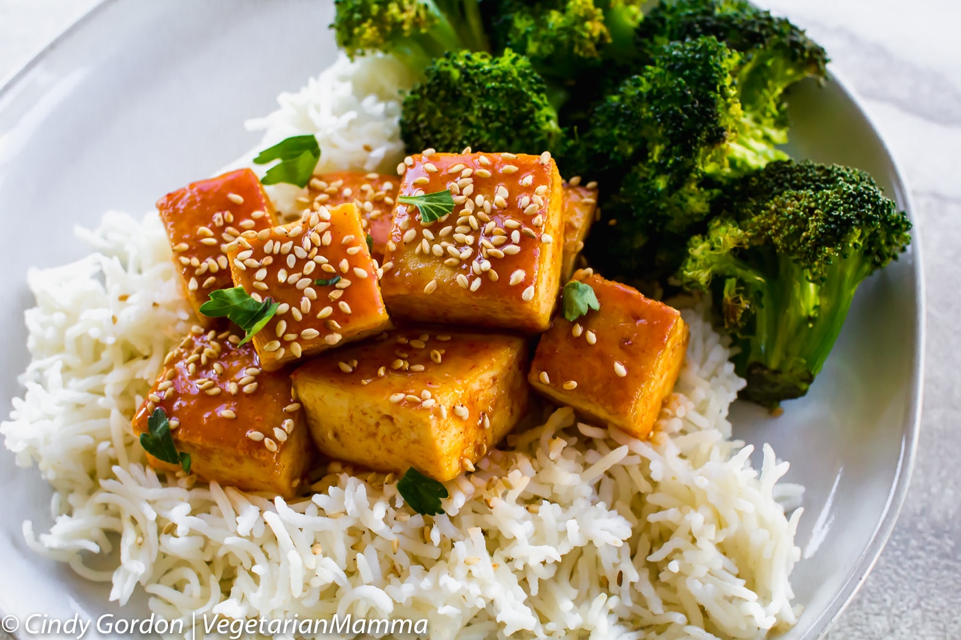 Honey Sriracha Tofu served with rice and broccoli on a white plate