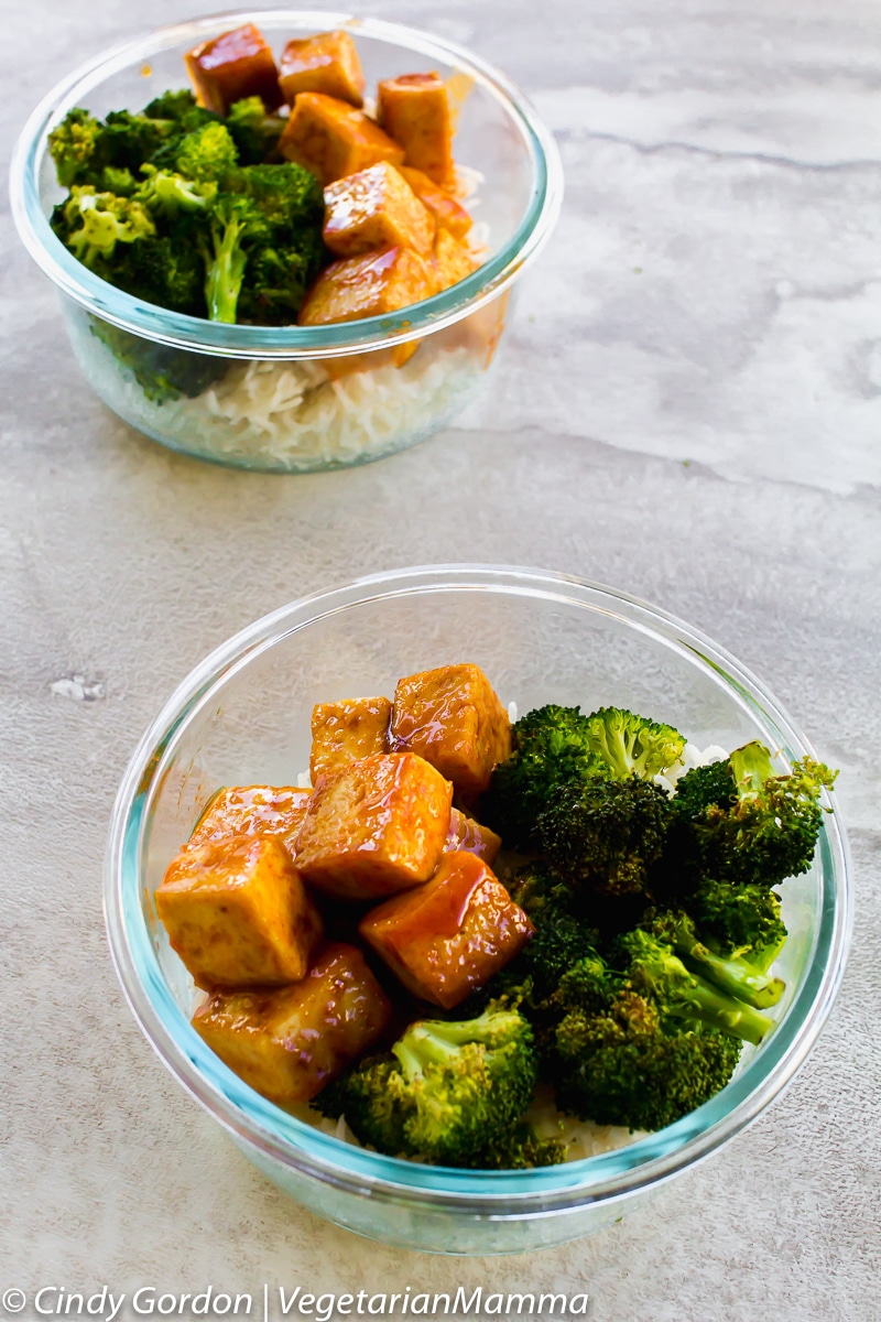 two small glass bowls full of tofu, broccoli, and rice
