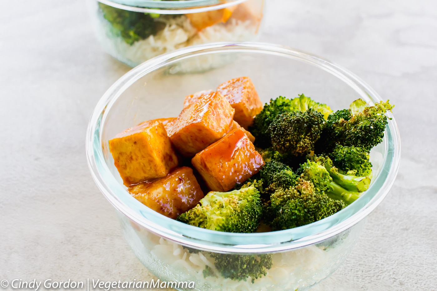 small glass bowl full of rice, broccoli, and tofu cubes.