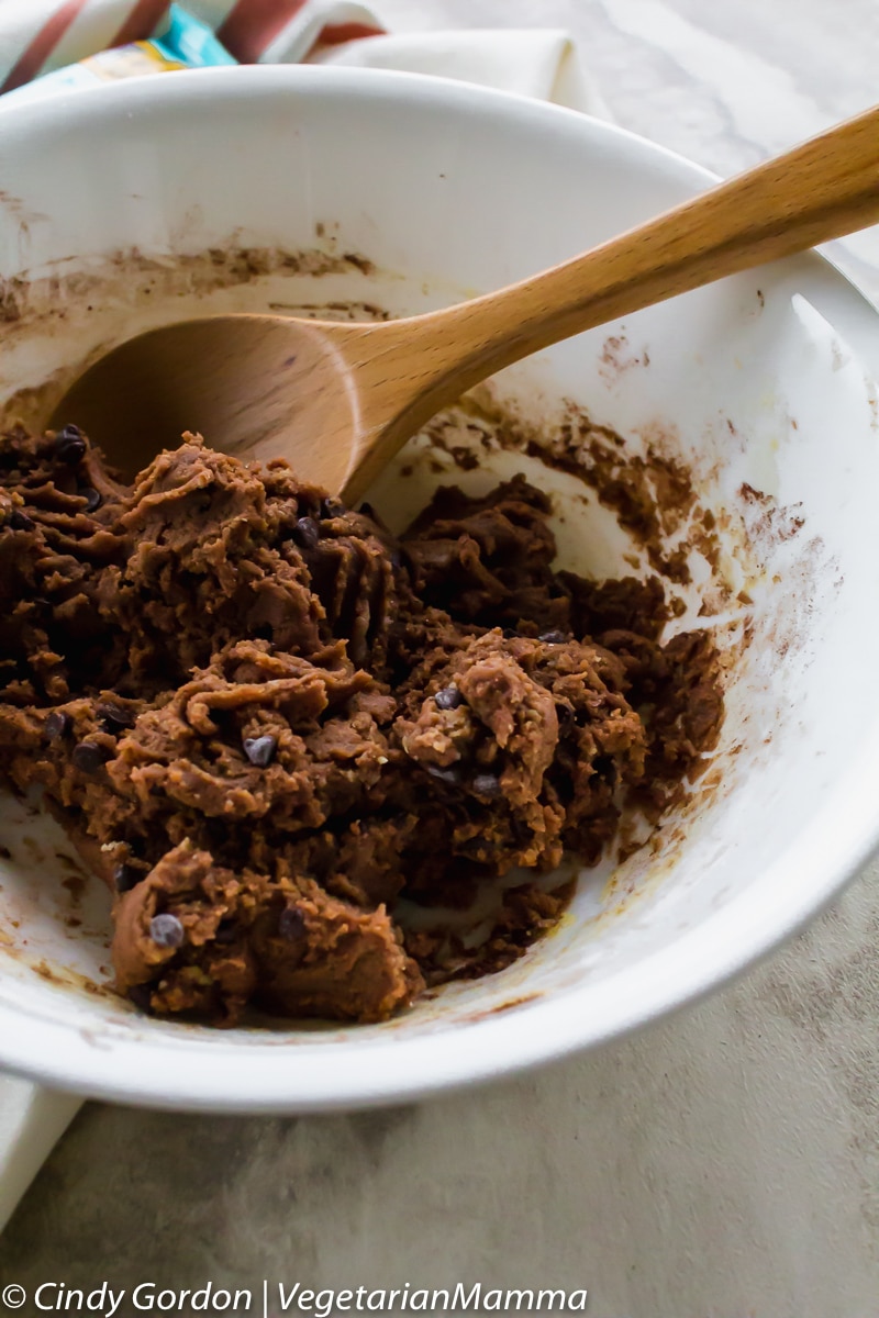 bowl of double chocolate cookie dough with a wooden spoon in it
