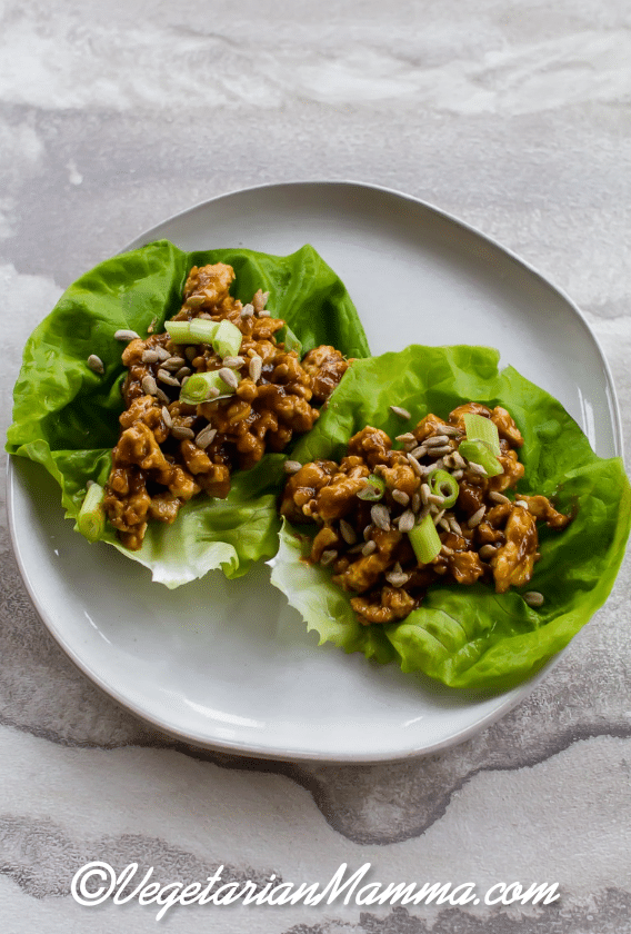 two Thai lettuce wraps on a white plate. 