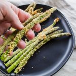 Hands holding Crispy Asparagus in Air Fryer