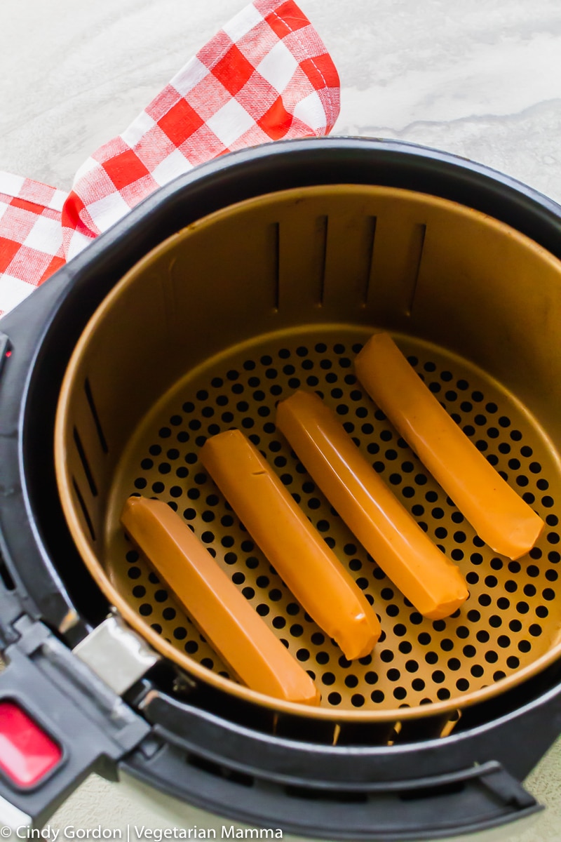 four veggie hot dogs in air fryer basket