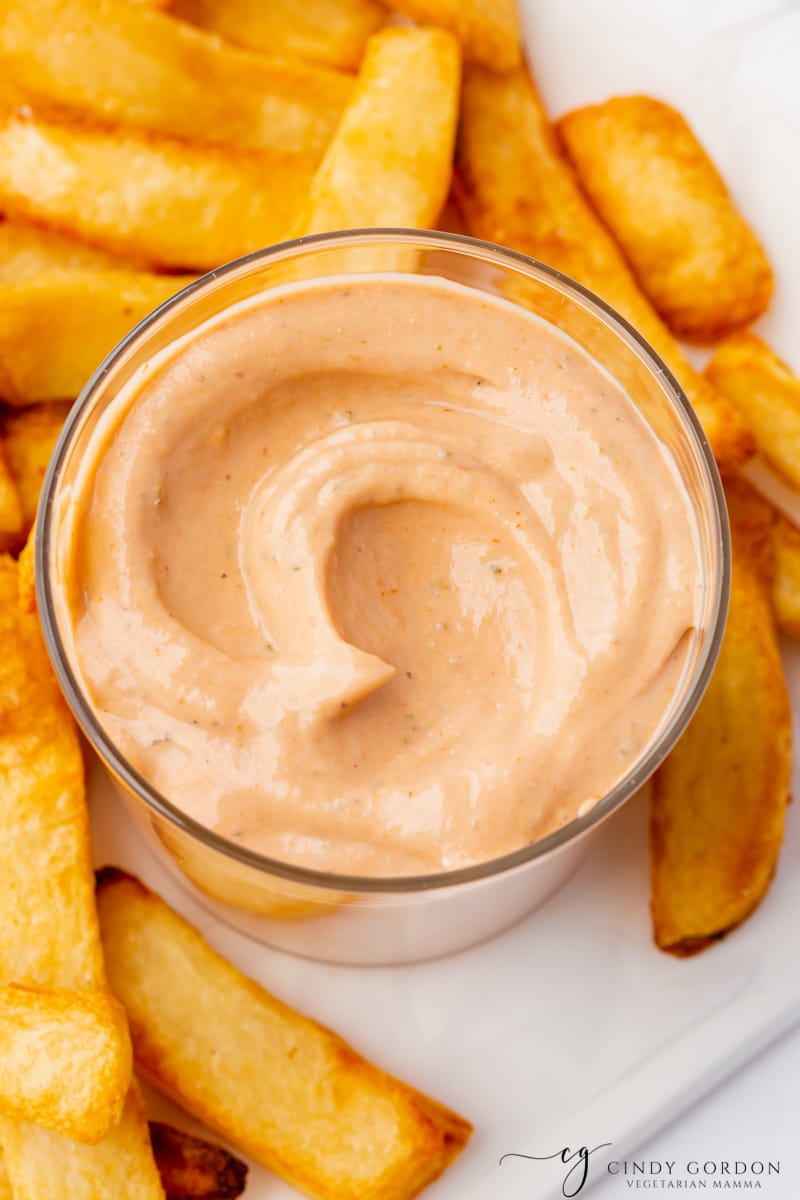 creamy bbq ranch dip on a plate with steak cut french fries. 