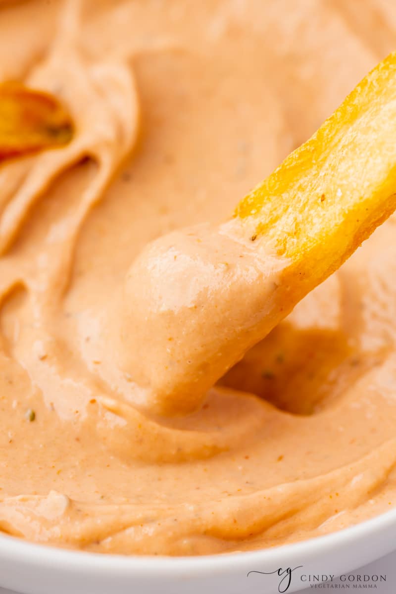 a french fry dipping into bbq ranch
