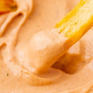 a french fry dipping into creamy bbq ranch