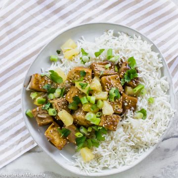 Overheat shot of pineapple ginger tofu on a white plate with white rice