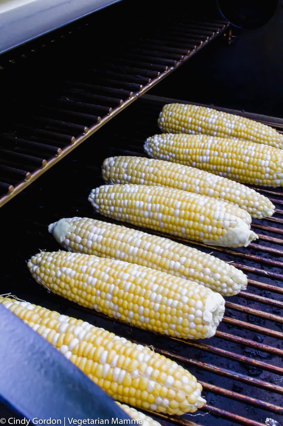 sweet corn on the grate of a smoker grill
