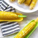 cooked corn on plates with butter