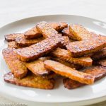 Cooked vegan air fryer bacon on a white plate