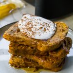 Pumpkin Air Fryer French Toast with whipped cream on top of staked bread
