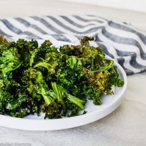 Side view of air fryer kale chips in round white bowl