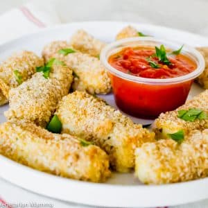 air fryer mozzarella sticks on a white plate and white background