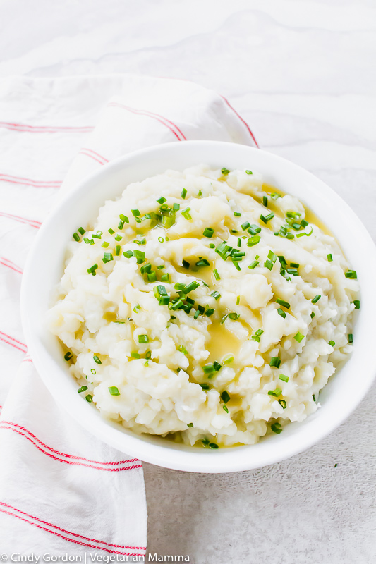 a bowl of mashed potatoes with melted butter and chives