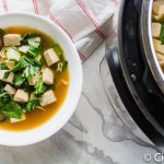 a bowl of ramen soup on a marble countertop next to an open Instant Pot