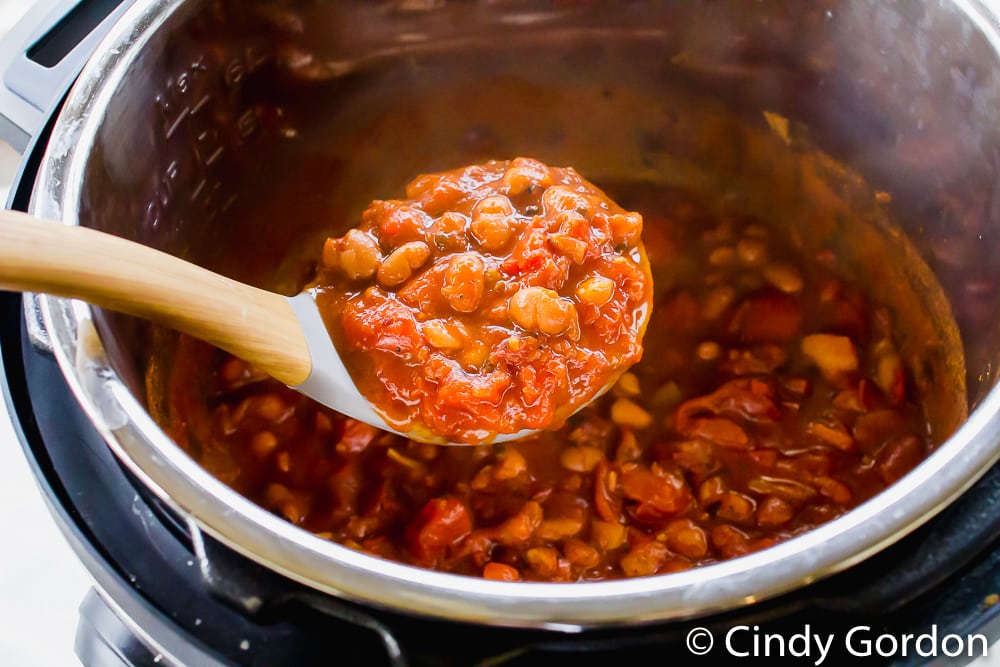 scoop of chili over top of an open instant pot with chili