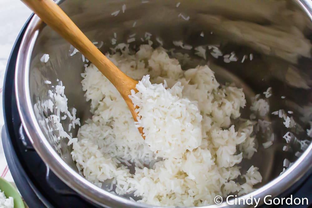 Jasmine rice on a wooden spoon in an Instant Pot